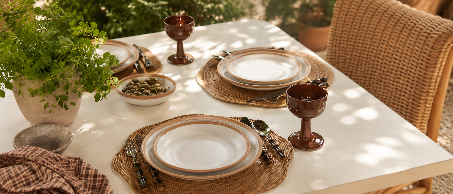 Natural ceramic tableware arranged on an outdoor dining table